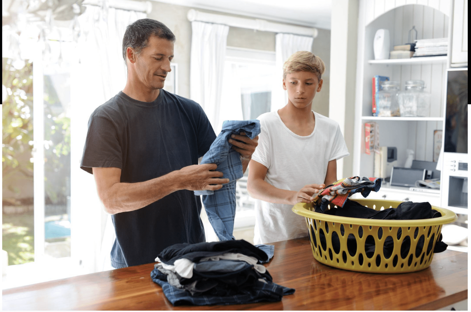 Father and teenaged son doing laundry